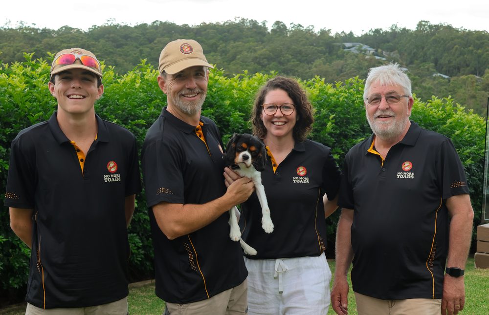 The No More Toads team with a puppy, outdoors in Queensland